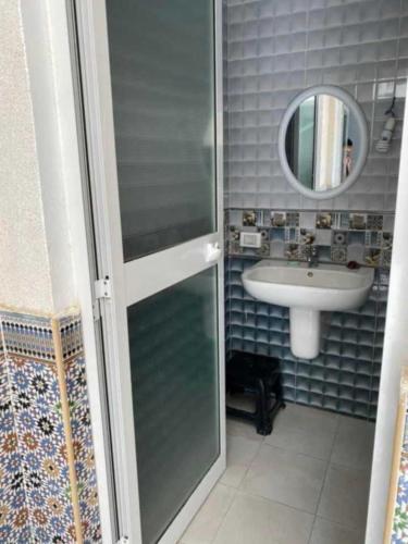 Un baño con ducha, lavabo y espejo. en Location vacances kelibia, en Kelibia
