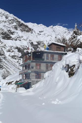 a building on top of a snow covered mountain at SALCHAN INN Home Stay in Takh
