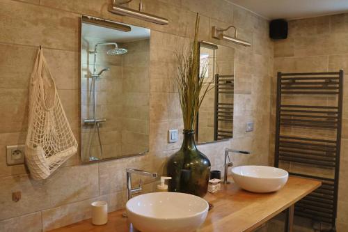 a bathroom with two sinks and a vase with a plant at Lepadaloft in Villeneuve-Saint-Georges