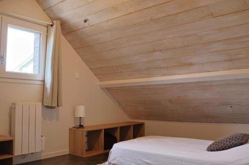 a bedroom with a bed and a wooden ceiling at Lepadaloft in Villeneuve-Saint-Georges
