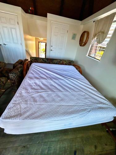 a large bed in a room with two white doors at Ocean-View 1BR Condo on Black Sands Beach, Pool, Hot Tub in Pahala