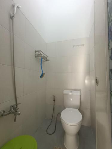 a bathroom with a toilet and a shower at Kamar Kost AC Luas Tengah Kota in Gombong