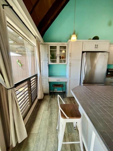 an rv kitchen with a table and a desk at Ocean-View 1BR Condo on Black Sands Beach, Pool, Hot Tub in Pahala