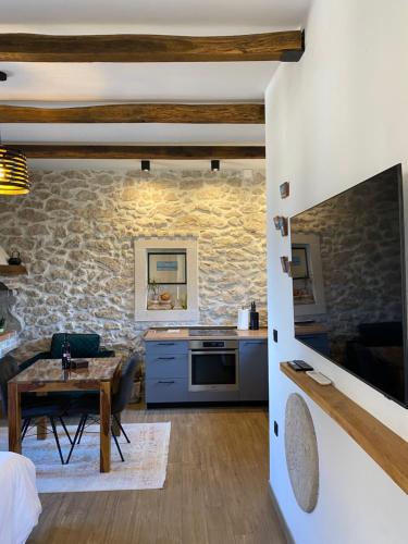 a kitchen and living room with a stone wall at Studio apartment Dalmatia in Nin