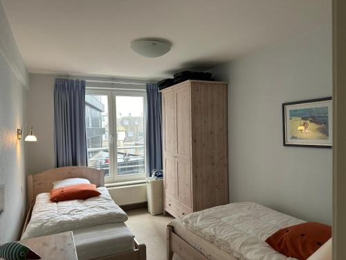 a bedroom with two beds and a window at Ruim appartement centrum Knokke Heist en zeezicht in Knokke-Heist