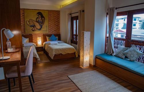 a bedroom with a bed and a table and a desk at Tara Art House Apartment 2 in Pātan