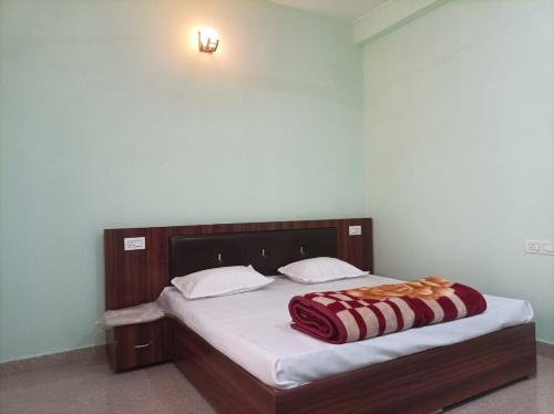 a bedroom with a bed with a red blanket on it at Riddhi Siddhi Homestay in Bhīm Tāl