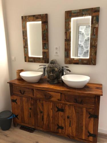 La salle de bains est pourvue de 2 lavabos et d'une coiffeuse en bois avec des miroirs. dans l'établissement l'ensemblière, à Plérin