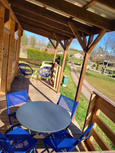 - une table et des chaises sur la terrasse couverte d'une cabine dans l'établissement Camping D'étival, à Étival-Clairefontaine