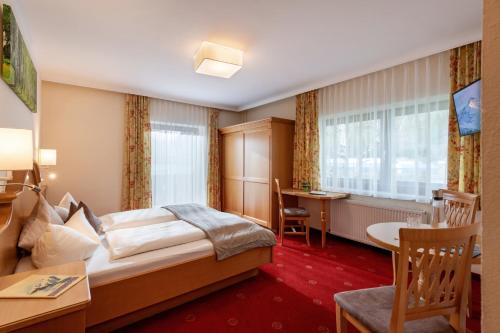 a hotel room with a bed and a desk at Hotel Garni Birkenhof in Mayrhofen