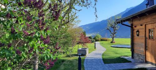 a garden with a walkway next to a building at Hotel Garni Birkenhof in Mayrhofen