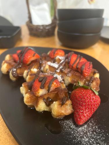 a plate of waffles with strawberries on a table at Penzión Liezky in Mýto pod Ďumbierom