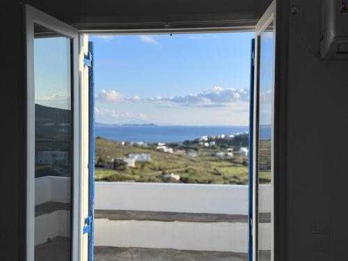 a view of the ocean through a sliding glass door at Notte d'Agosto-Sleeps 5-Private Balcony-Sea View in Agios Ioannis Tinos