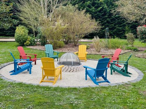 - un groupe de chaises colorées autour d'un foyer extérieur dans l'établissement Cottage, 2 Adults 2 kids, jacuzzi, sport room, pétanque, BBQ, garden, à Cheverny