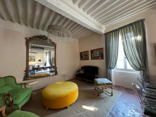 - un salon avec un pouf jaune et un miroir dans l'établissement Atlantes de Saint Saturnin, à Saint-Saturnin-lès-Apt