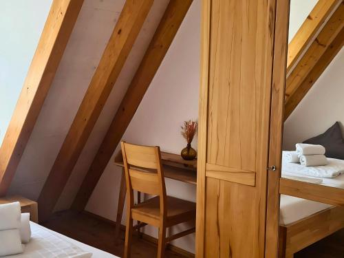 Una habitación con un escritorio y una silla en un ático. en Auszeit beim Winzer- FeWo Idig, en Neustadt an der Weinstraße