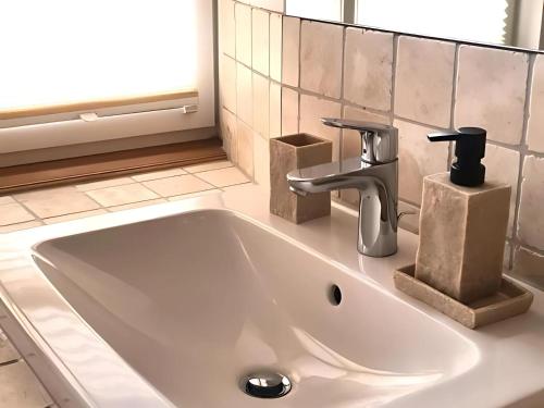 Un lavabo blanco con grifo en un baño. en Auszeit beim Winzer- FeWo Idig, en Neustadt an der Weinstraße