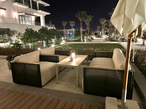 a patio with a couch and a table with an umbrella at Address Beach Resort Residences Bahrain in Manama