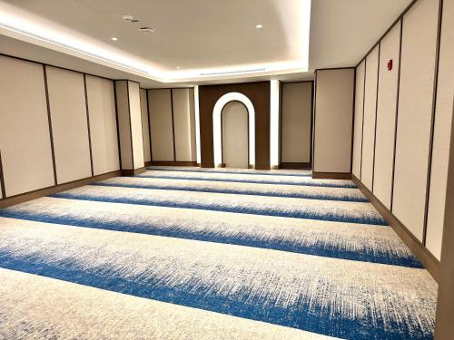 a room with blue carpeted floors and a hallway at Address Beach Resort Residences Bahrain in Manama