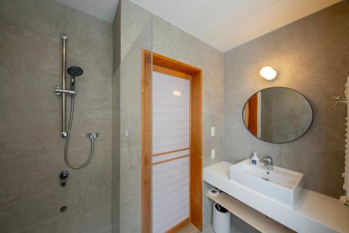 a bathroom with a shower and a sink and a mirror at Chihiro Niseko in Kutchan