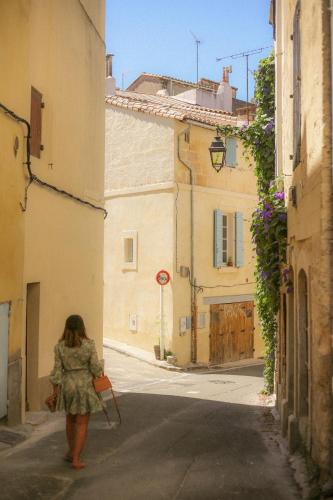une femme marchant dans une rue dans une allée dans l'établissement Bel appartement proche arènes, à Arles