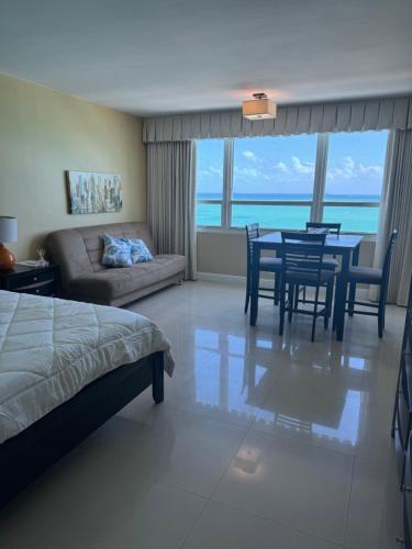 a bedroom with a bed and a table and chairs at Castle beach studio,tennis court and swimming pool with beach access in Miami Beach