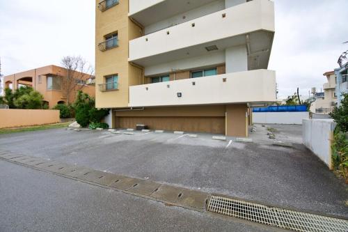 an empty parking lot in front of a building at ガネーシャ 501 in Tokeshi