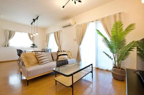 a living room with a couch and a glass table at ガネーシャ 501 in Tokeshi