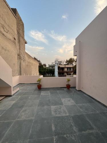 an empty balcony with two potted plants on a building at Whispers of Peace Villa in Amritsar