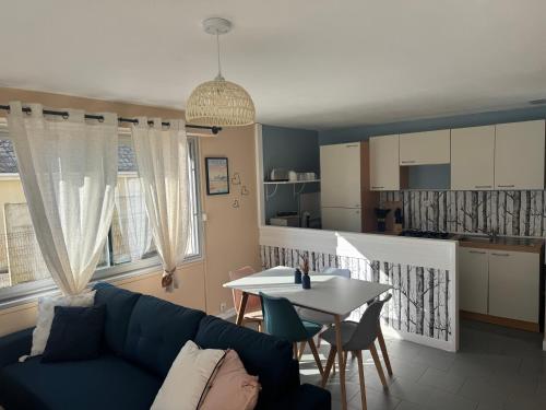 un salon avec un canapé bleu et une table dans l'établissement SUNLIGHT Merlimont Appartement Plage Merlimont 10 mn Berck le Touquet, à Merlimont