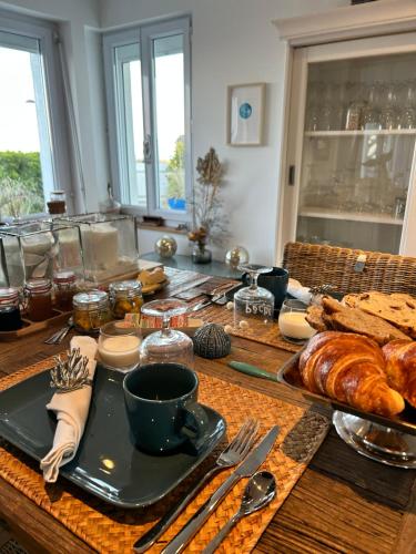 - une table avec du pain et des croissants dans l'établissement L'écume de mer, à Barneville-Carteret