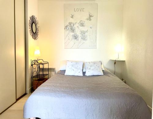 une chambre avec un lit avec deux oreillers dans l'établissement Loucasa Location les Issambres, aux Issambres