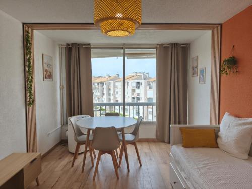 un salon avec une table et un canapé dans l'établissement Chez Léna, au Grau-du-Roi