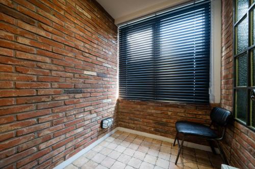 a brick room with a chair and a brick wall at JB Design Hotel in Busan