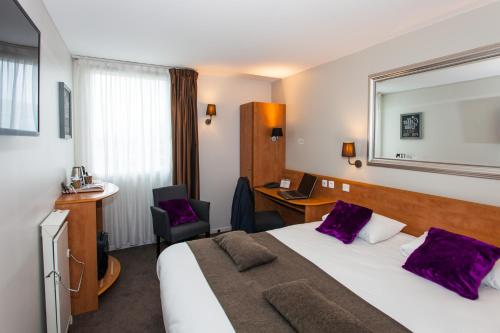 En eller flere senge i et værelse på HOTEL DU PARC Roissy Villepinte - Parc des Expositions