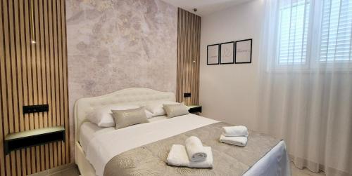a bedroom with a large bed with towels on it at GREEN cozy apartment with shared POOL in Split