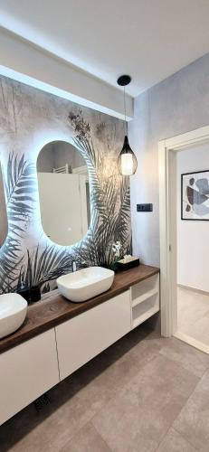 a bathroom with two sinks and a large mirror at GREEN cozy apartment with shared POOL in Split