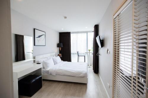 a white bedroom with a bed and a sink at Modern Condo in Nimman P608 by Pimolplace in Chiang Mai