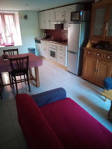 una cucina con un tavolo e un divano in una stanza di L'OASIS maisonnette centre ville 3 chambres terrasse espace vert privé parc sainte croix center parc 20 minutes a Sarrebourg
