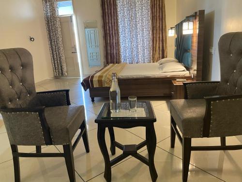a bedroom with a bed and a table and chairs at Pine Wood Villa in Mānānwāla