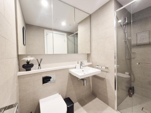 a bathroom with a sink toilet and a shower at Timeless Black n White Charm 2BR w Kids room in Sydney