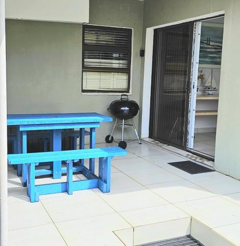 a pair of blue benches sitting on a porch at 10 Coral Cove Beach Lodge in Ballito