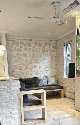 a living room with a couch against a brick wall at 10 Coral Cove Beach Lodge in Ballito