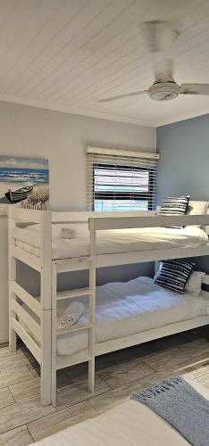 a bedroom with a large bunk bed and a window at 10 Coral Cove Beach Lodge in Ballito