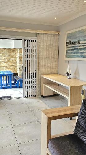a living room with a table and a bench at 10 Coral Cove Beach Lodge in Ballito