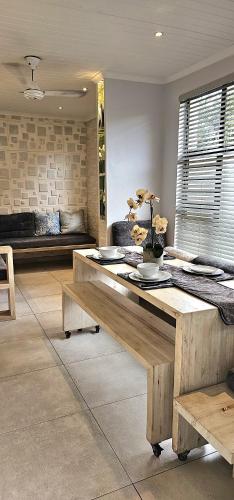 a living room with a wooden table and a couch at 10 Coral Cove Beach Lodge in Ballito
