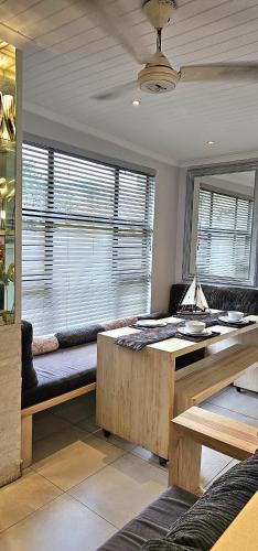 a room with a large window and a large wooden table at 10 Coral Cove Beach Lodge in Ballito