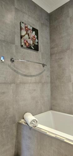 a bathroom with a bath tub and a towel at 10 Coral Cove Beach Lodge in Ballito