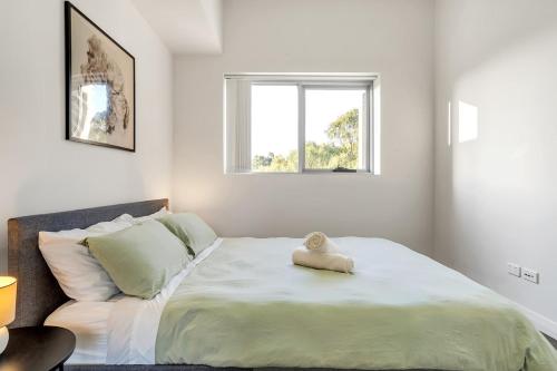een slaapkamer met een bed met een knuffeldier erop bij 41B Modern 1 Bedroom Abnb-Style apartment Free Parking in Bankstown