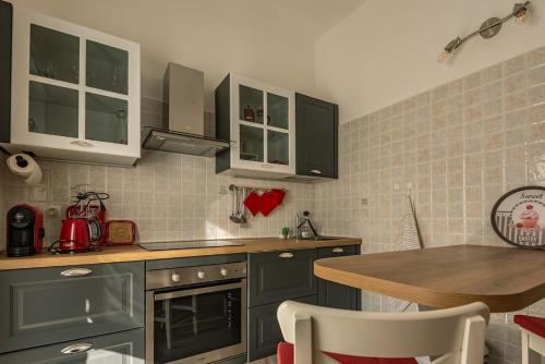 a kitchen with green cabinets and a wooden table at Elegante e Panoramico Bilocale La Libellula in Tavigliano